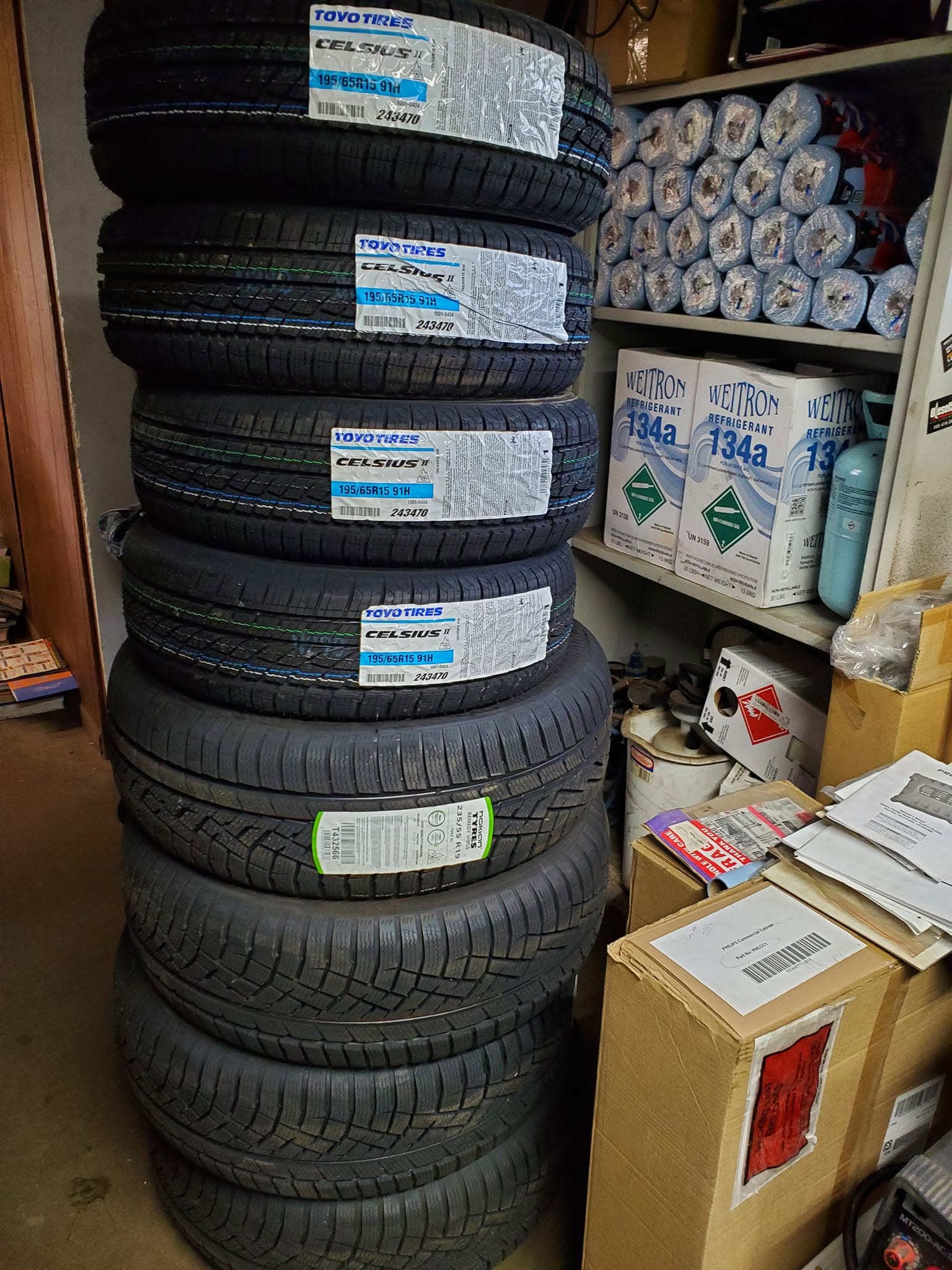 Tires awaiting installation at Honest Auto, including Three Peak Mountain Snowflake all-season tires